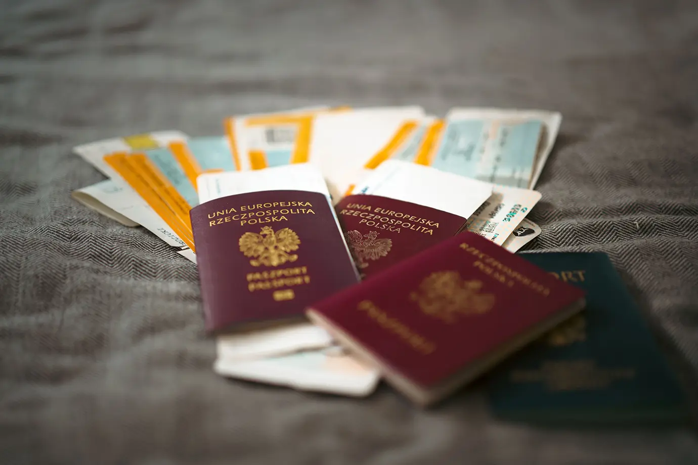Multiple international passports and flight itineraries resting on a fabric surface, highlighting essential documents for Dubai Visa Requirements.
