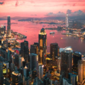 Hong Kong Travel Cost - Cityscape of the Victoria Harbour region of Hong Kong during a magical sunset