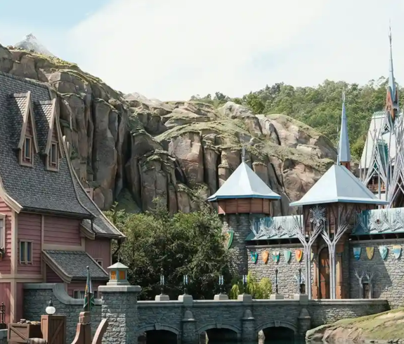Nordic-style village buildings and stone castle spires in the World of Frozen themed land, featured in any Hong Kong Disneyland Guide.