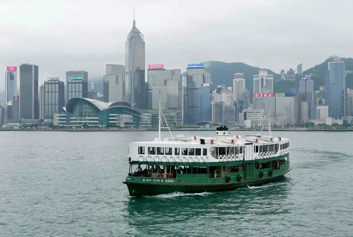 A passenger ferry cruising along the water against a city skyline, illustrating cross-border trips to Macau under Hong Kong Visa Requirements. 